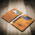 Tyler vertical wallet in full-grain tan vegetable-tanned leather, standing upright showing card slots and slim profile