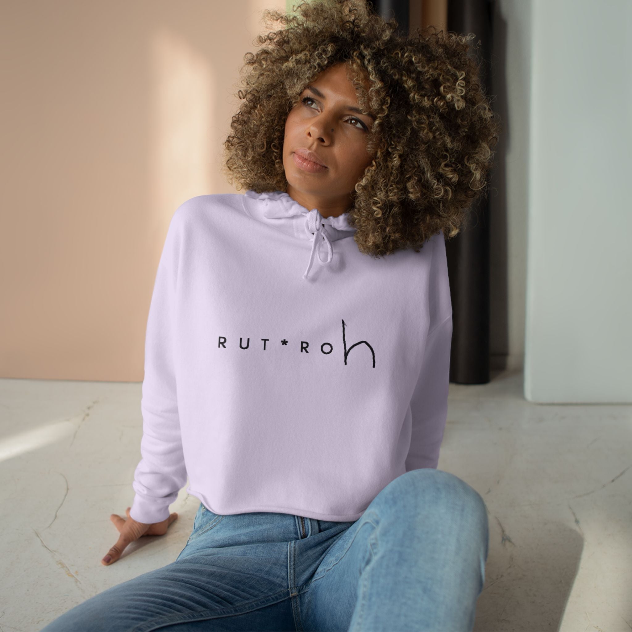 White cropped hoodie with minimal hand-drawn RUT*ROh chest graphic, dropped shoulders and raw hem, casual streetwear style