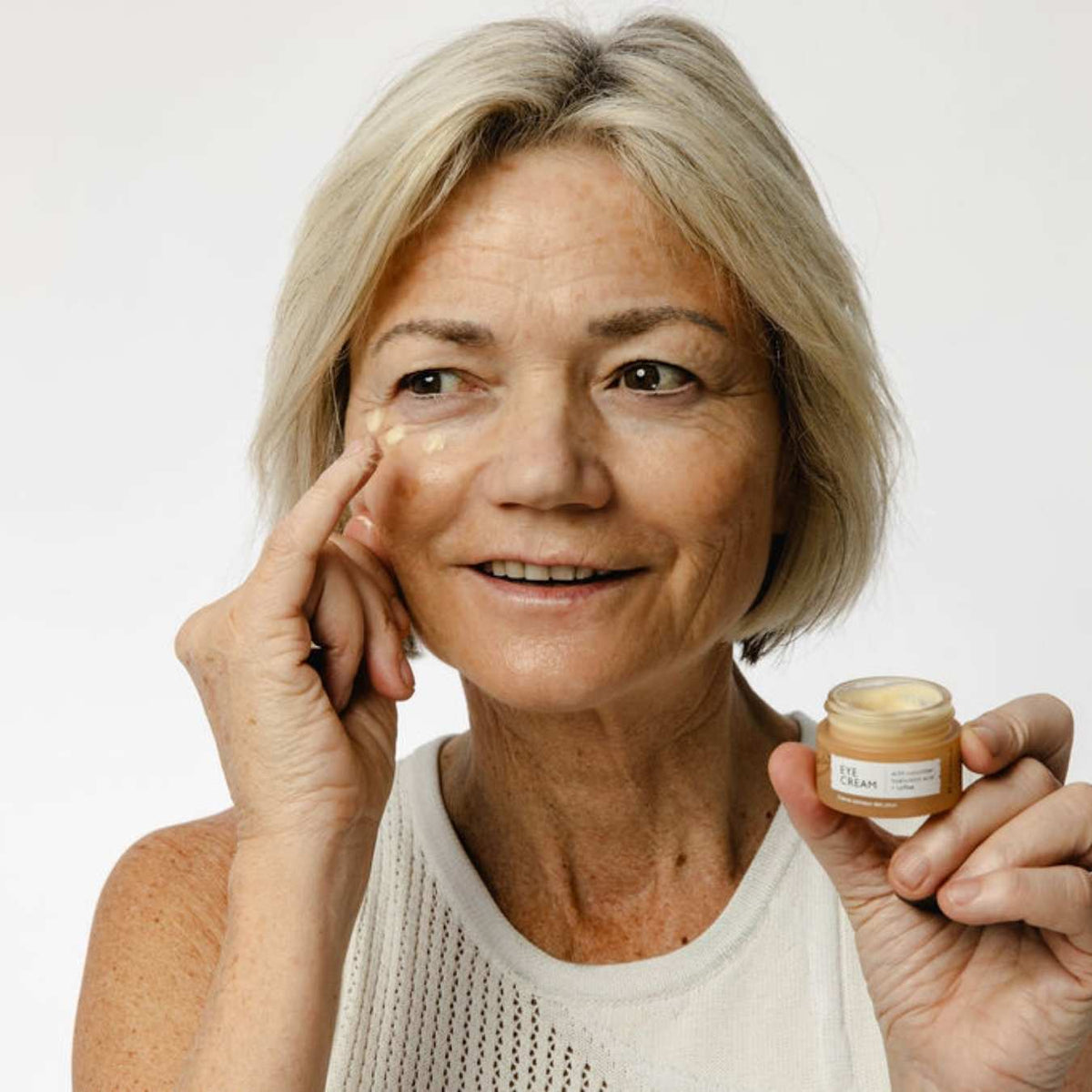 UpCircle eye cream in a glass jar with aluminium lid, showing coffee oil and hyaluronic acid formula for dark circles