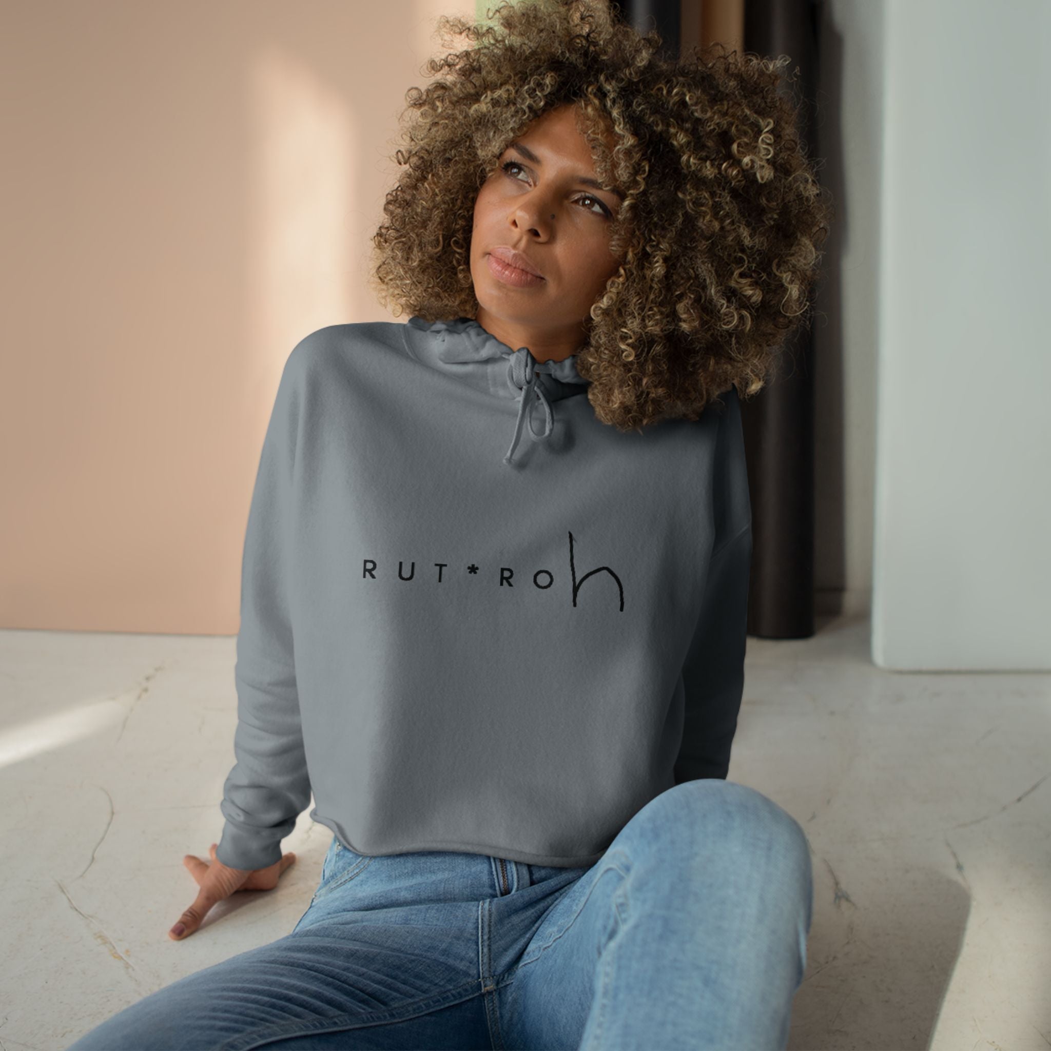 White cropped hoodie with minimal hand-drawn RUT*ROh chest graphic, dropped shoulders and raw hem, casual streetwear style
