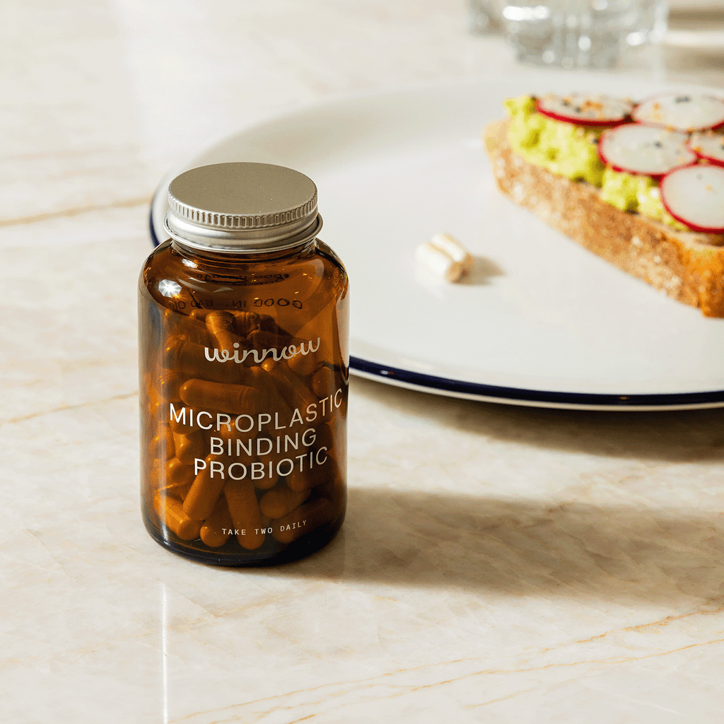 Daily probiotic starter kit in a reusable glass jar with white capsules and minimal packaging