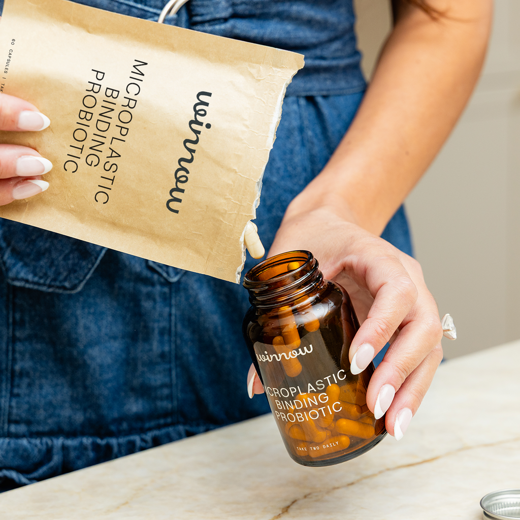 Daily probiotic starter kit in a reusable glass jar with white capsules and minimal packaging