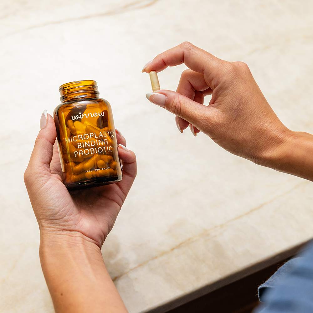 Daily probiotic starter kit in a reusable glass jar with white capsules and minimal packaging
