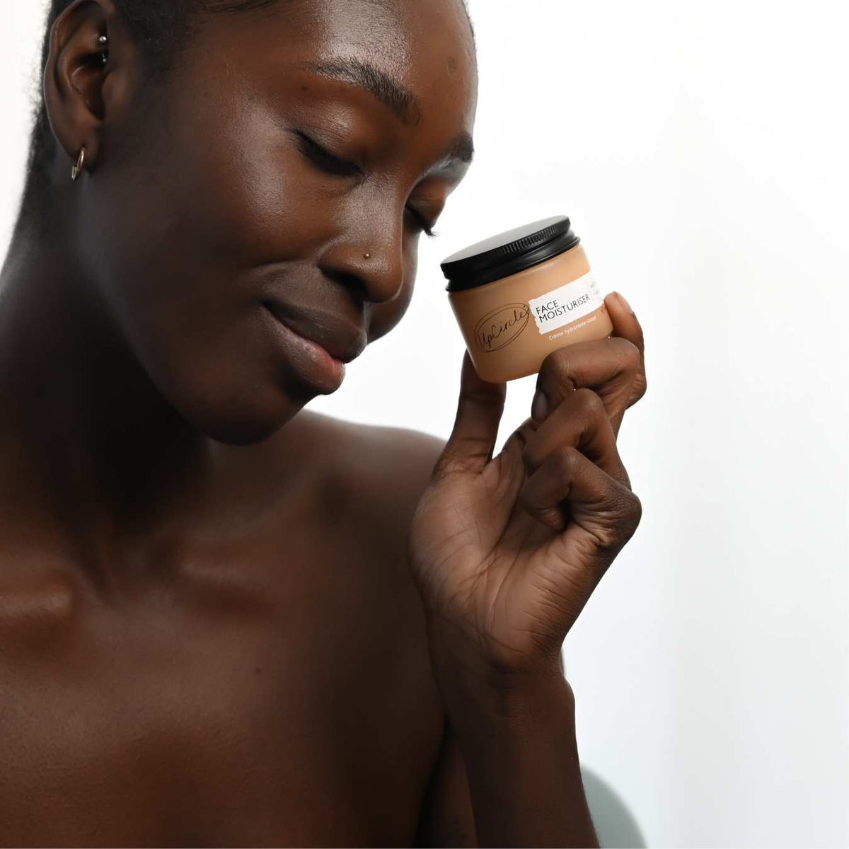 UpCircle Vitamin E Face Moisturizer in a glass jar with aluminum lid on a clean neutral background