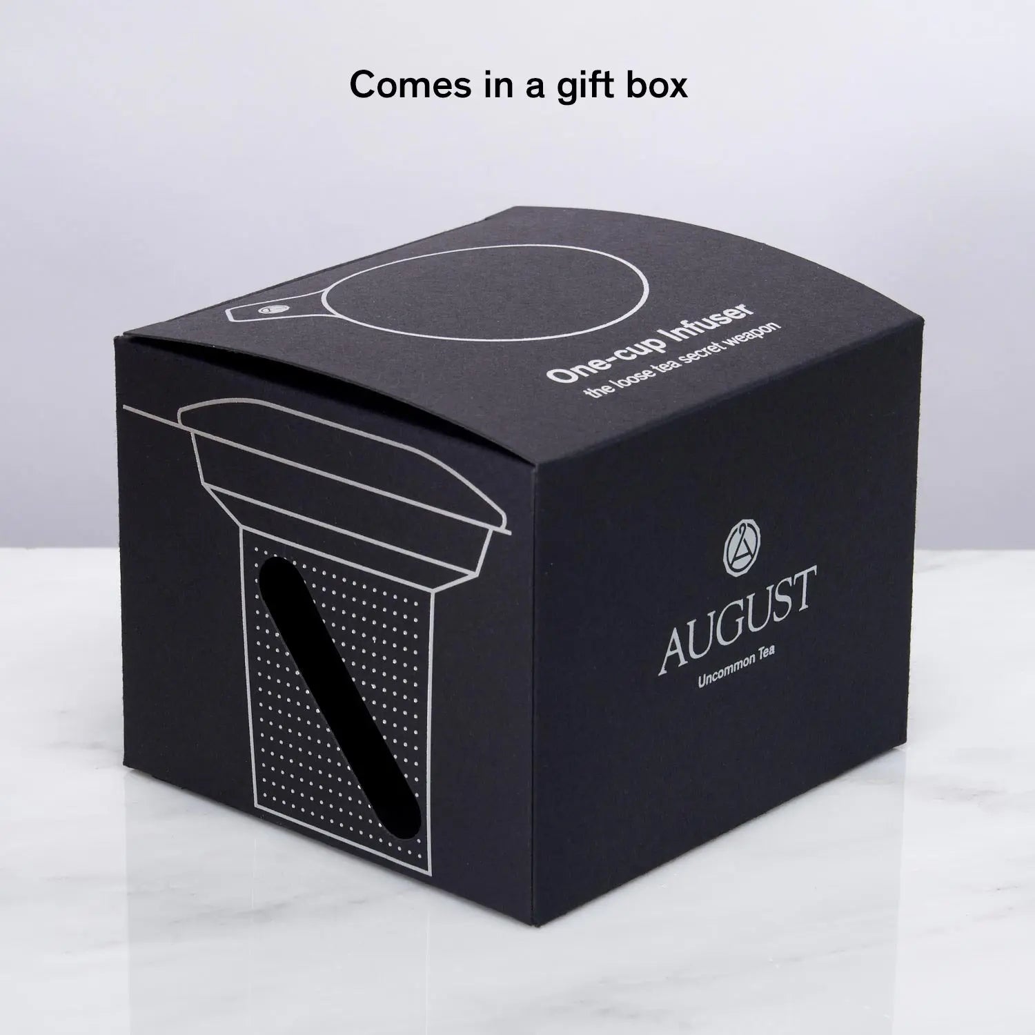 Stainless steel one-cup loose leaf tea infuser resting on its silicone lid coaster beside a ceramic mug