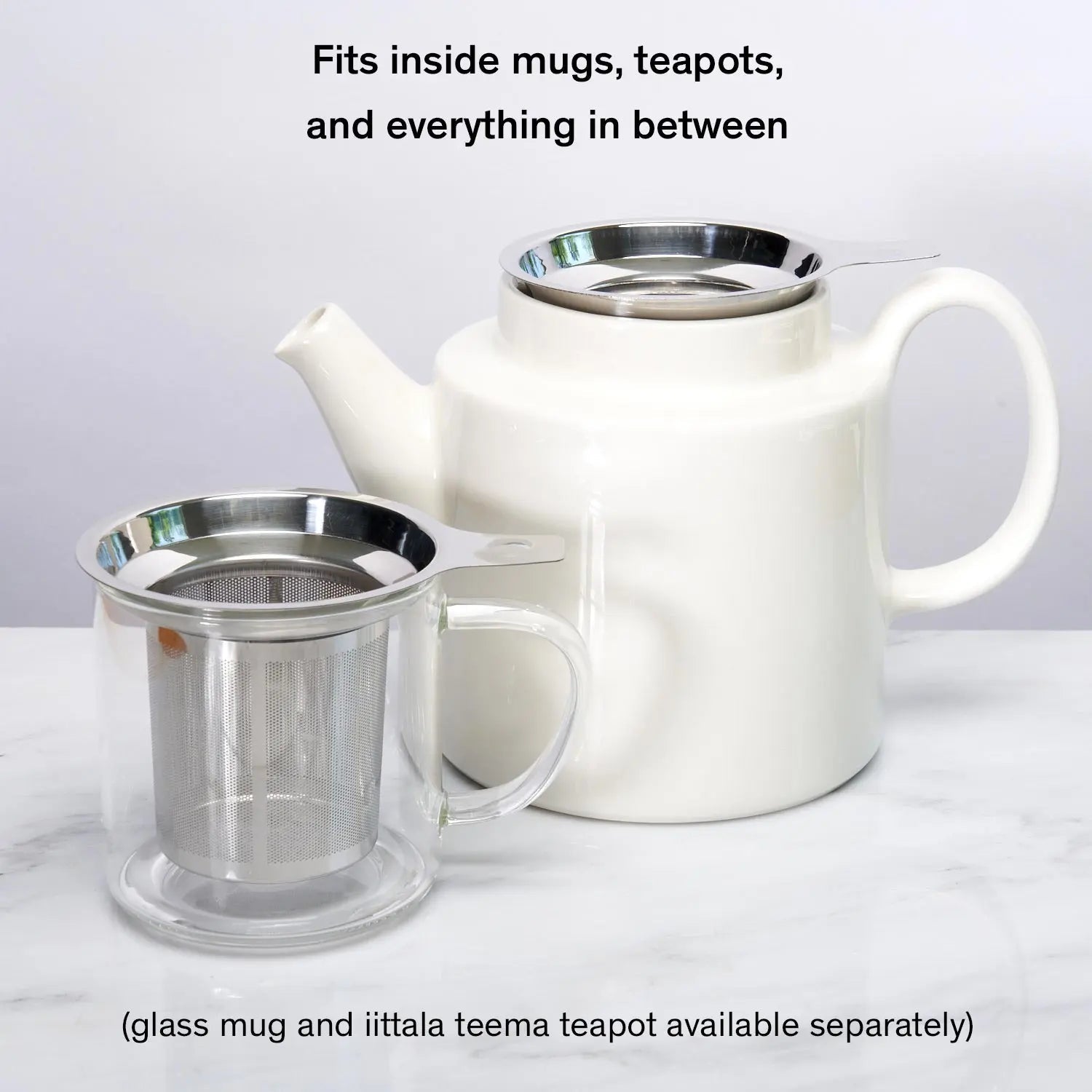 Stainless steel one-cup loose leaf tea infuser resting on its silicone lid coaster beside a ceramic mug