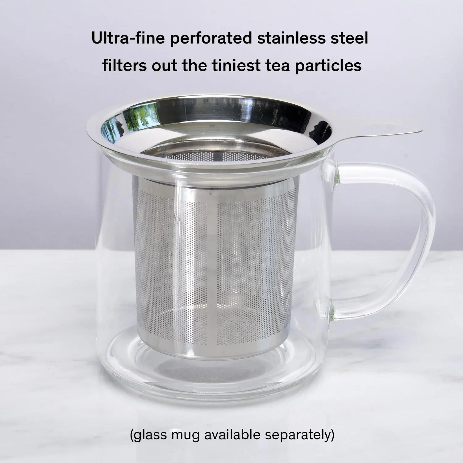Stainless steel one-cup loose leaf tea infuser resting on its silicone lid coaster beside a ceramic mug