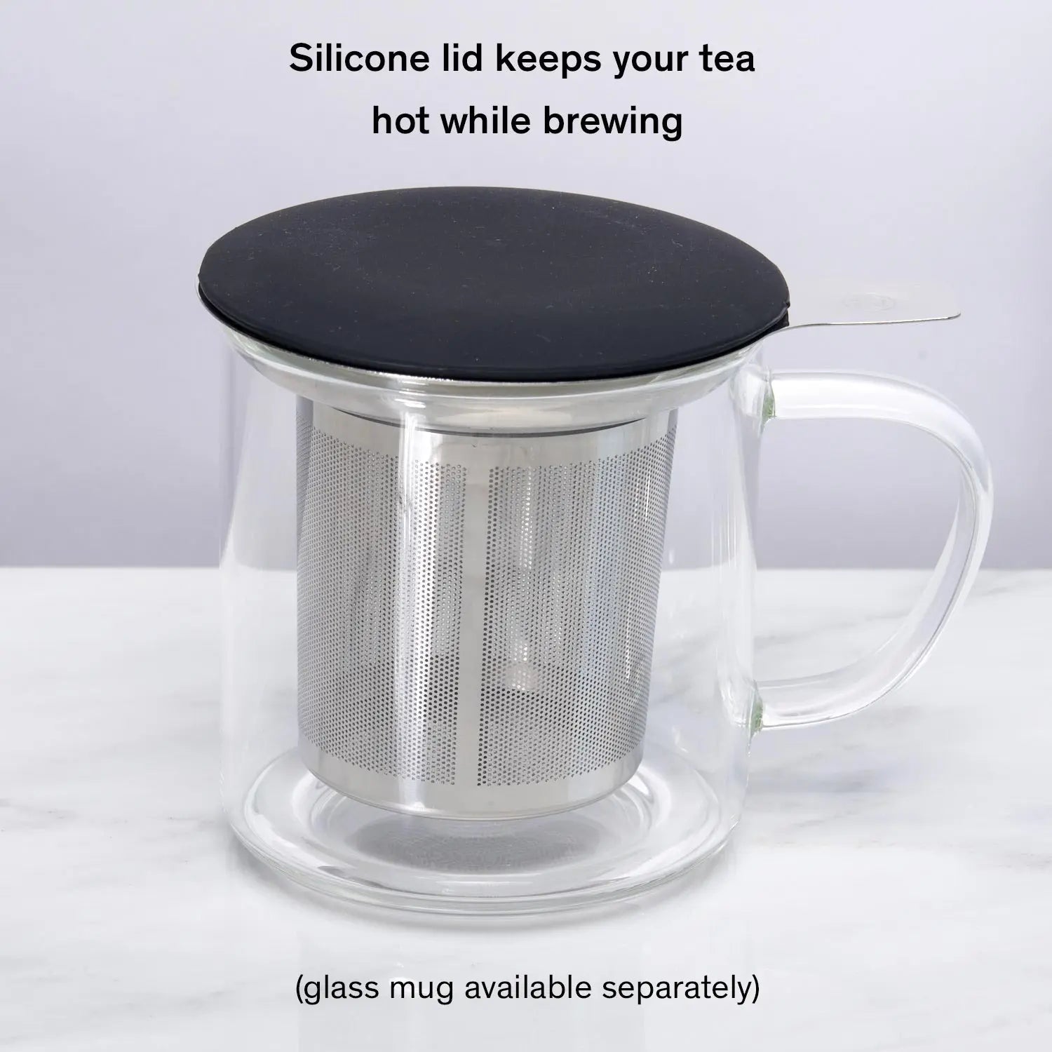 Stainless steel one-cup loose leaf tea infuser resting on its silicone lid coaster beside a ceramic mug