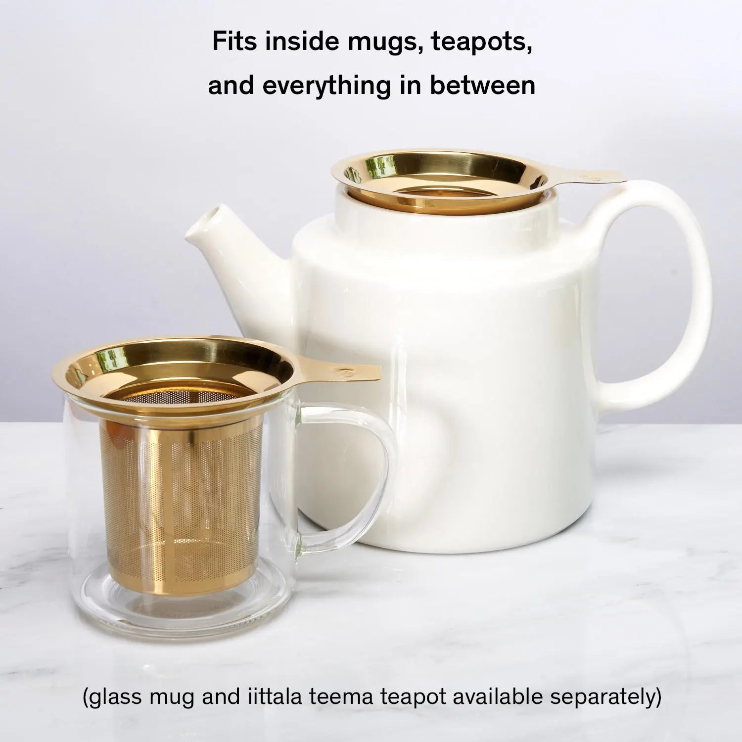 Stainless steel one-cup loose leaf tea infuser resting on its silicone lid coaster beside a ceramic mug
