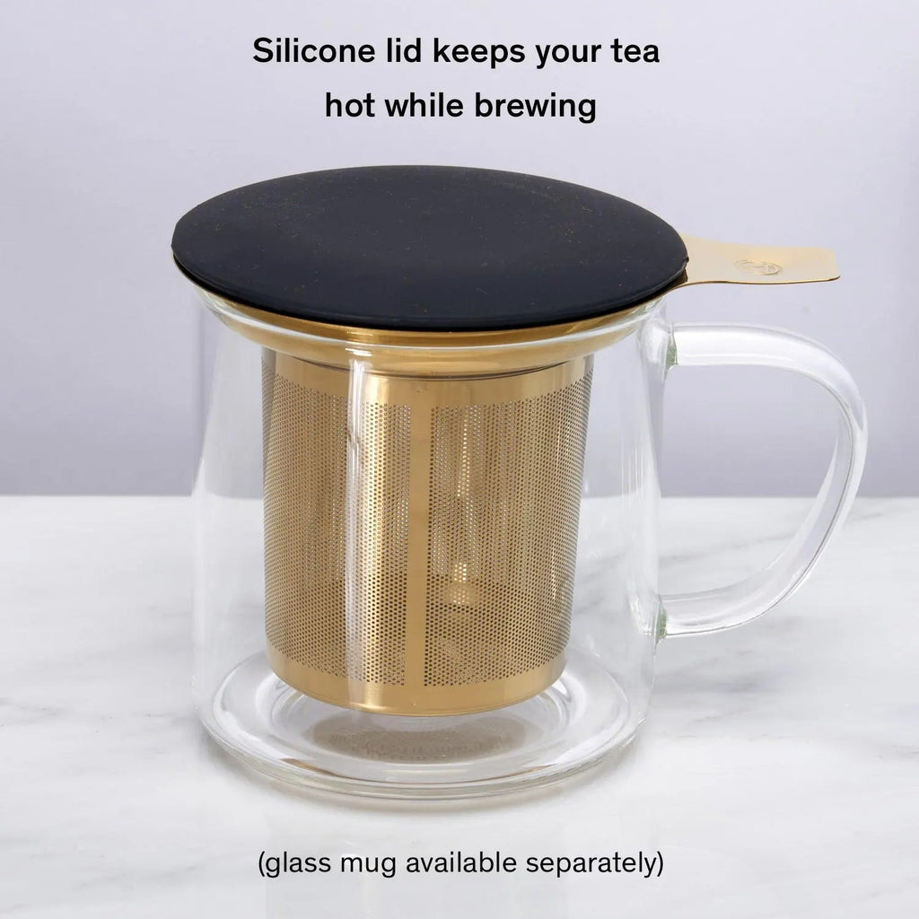 Stainless steel one-cup loose leaf tea infuser resting on its silicone lid coaster beside a ceramic mug