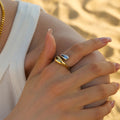 Close-up of a slim 18K gold-plated serpent wrap open ring worn on a finger against a neutral background