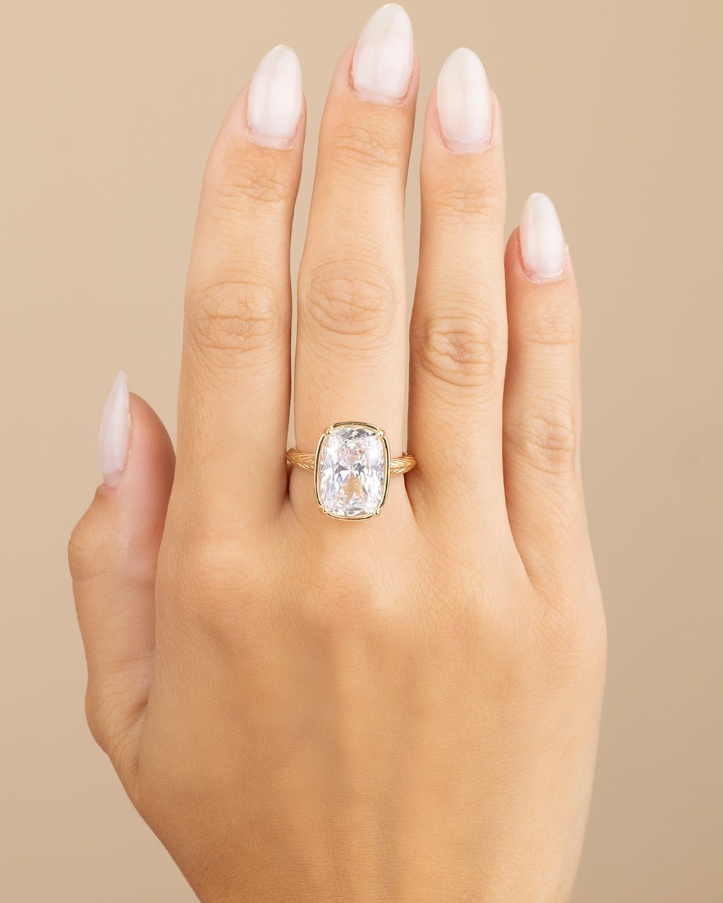 Elongated cushion-cut cubic zirconia cocktail ring in gold-plated sterling silver on a hand, showing large faceted stone and slim band