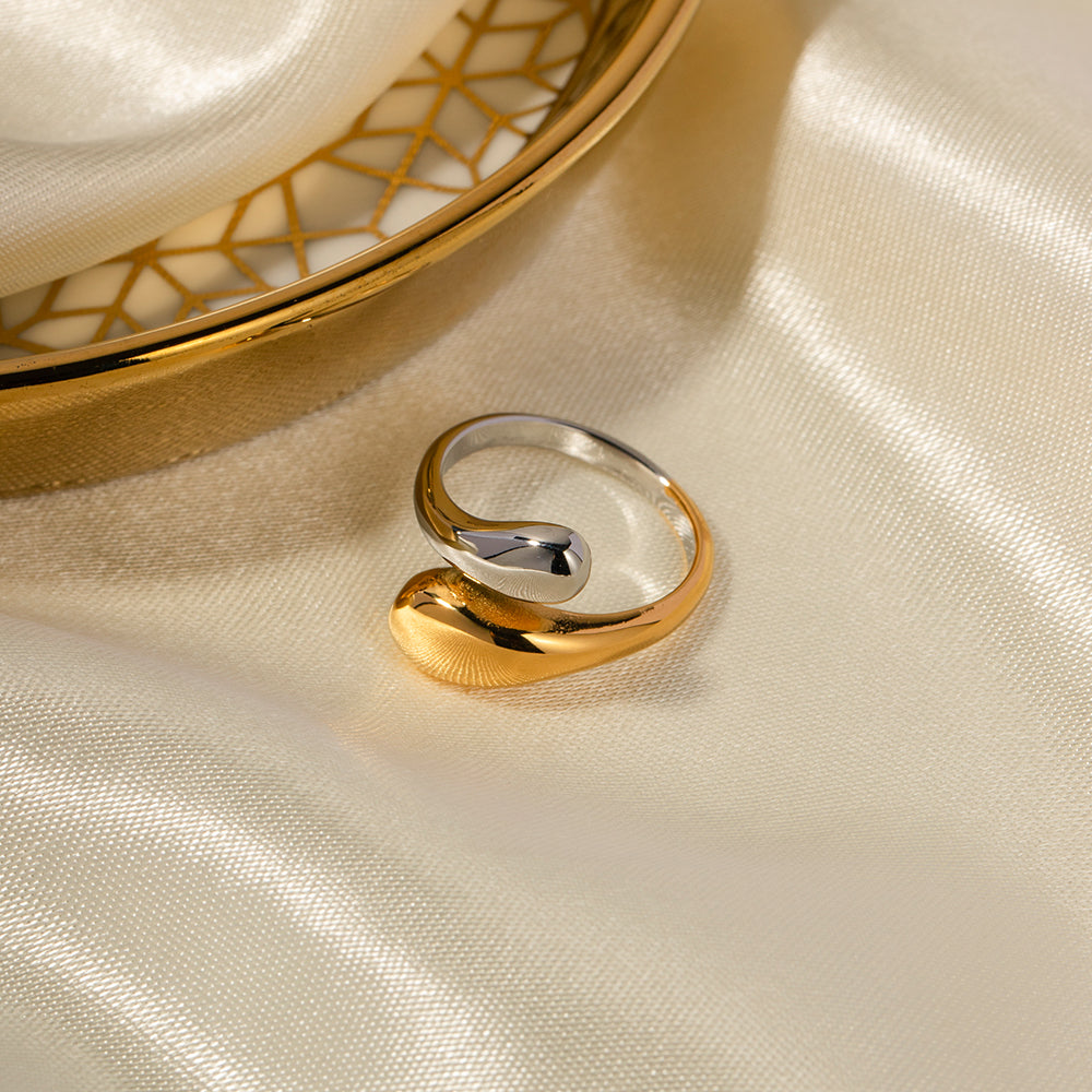 Close-up of a slim 18K gold-plated serpent wrap open ring worn on a finger against a neutral background