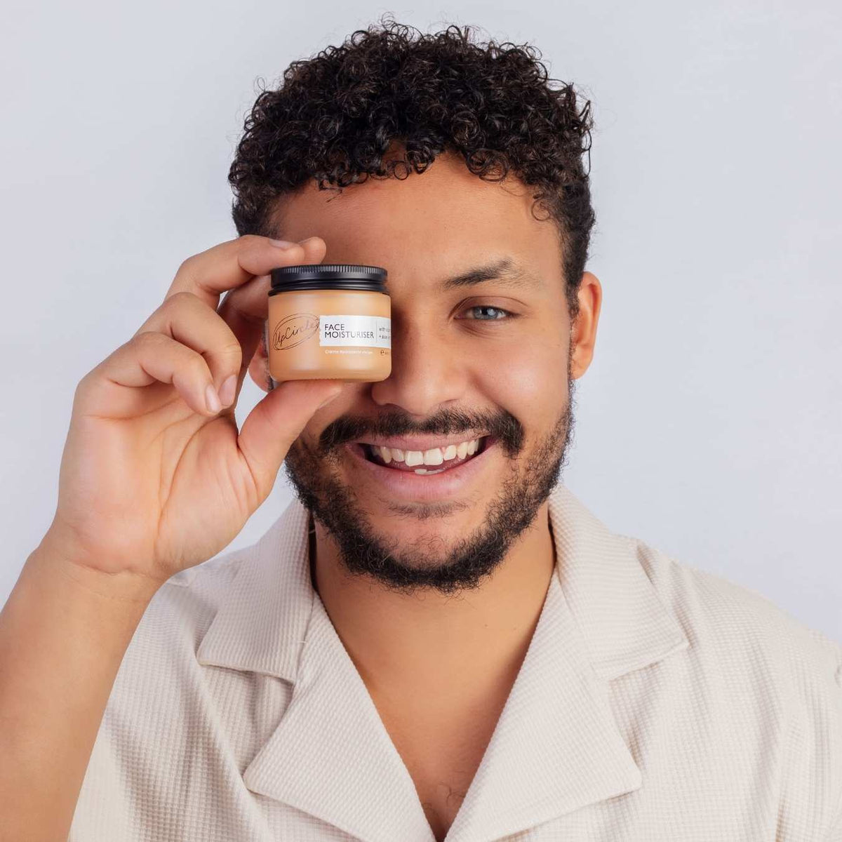 UpCircle Vitamin E Face Moisturizer in a glass jar with aluminum lid on a clean neutral background