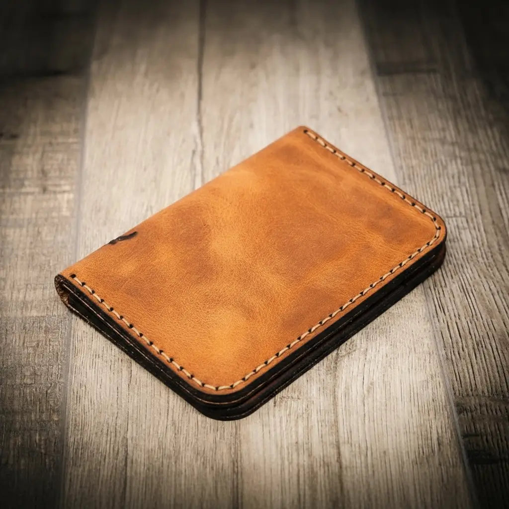 Tyler vertical wallet in full-grain tan vegetable-tanned leather, standing upright showing card slots and slim profile