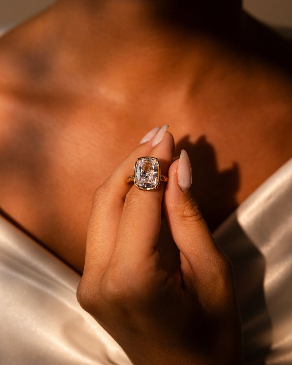 Elongated cushion-cut cubic zirconia cocktail ring in gold-plated sterling silver on a hand, showing large faceted stone and slim band