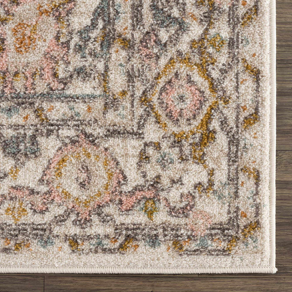 Herstmonceux traditional area rug with vintage pattern in charcoal, mustard, dusty pink, and off-white tones on a medium pile