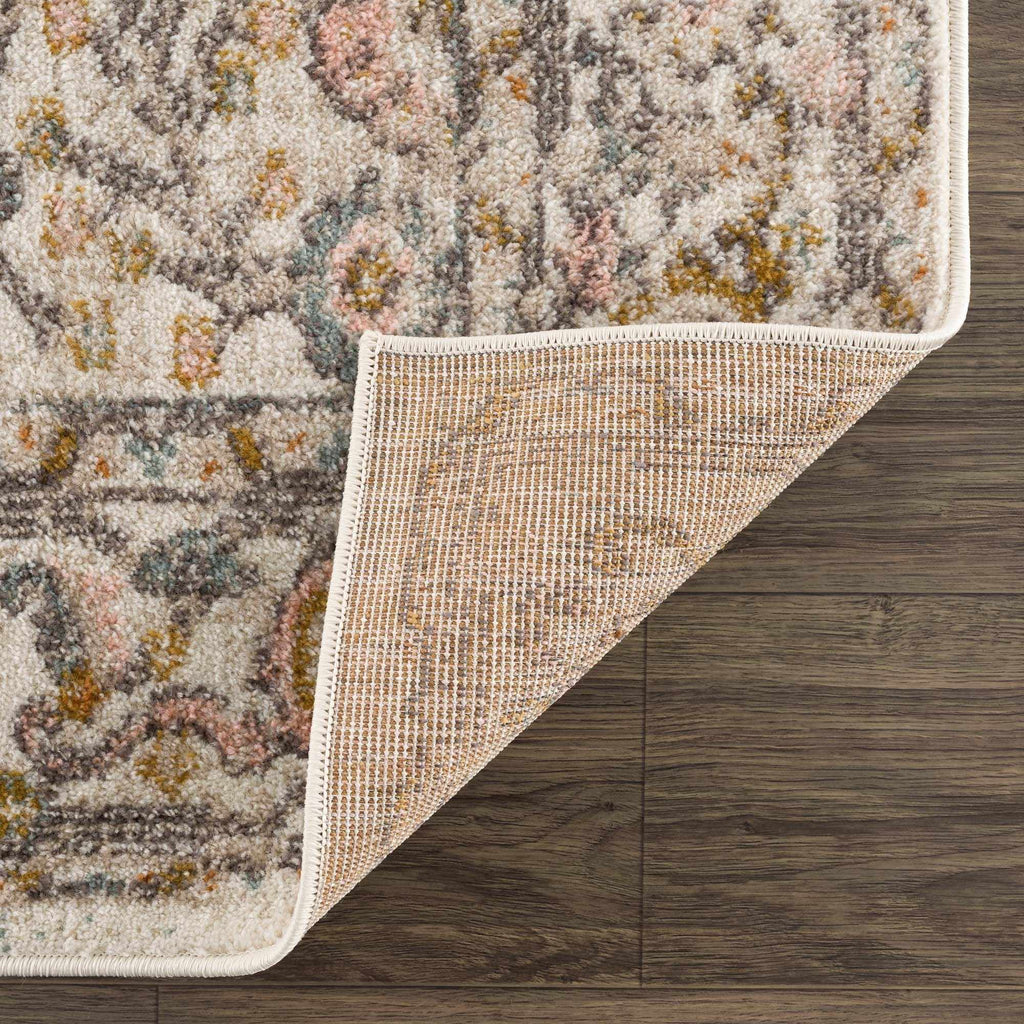 Herstmonceux traditional area rug with vintage pattern in charcoal, mustard, dusty pink, and off-white tones on a medium pile