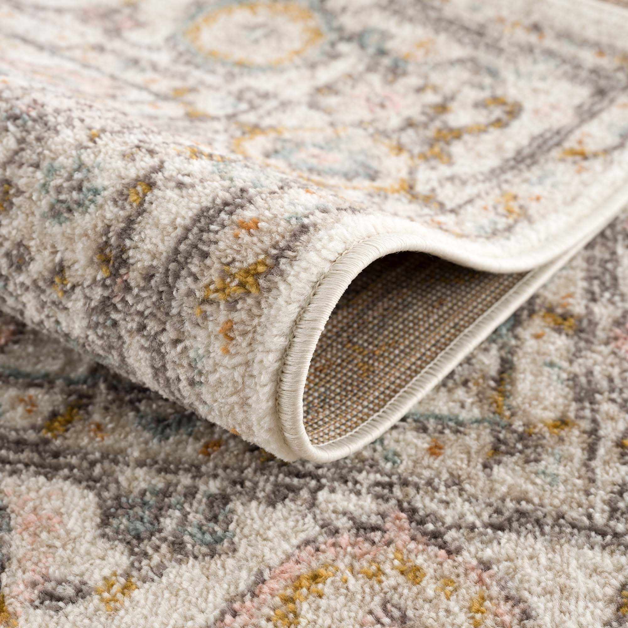Herstmonceux traditional area rug with vintage pattern in charcoal, mustard, dusty pink, and off-white tones on a medium pile