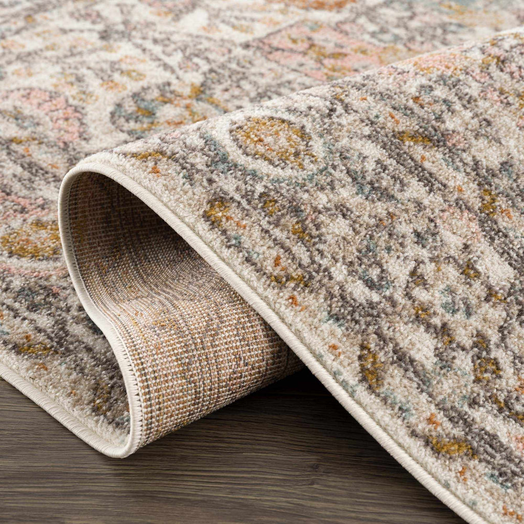 Herstmonceux traditional area rug with vintage pattern in charcoal, mustard, dusty pink, and off-white tones on a medium pile