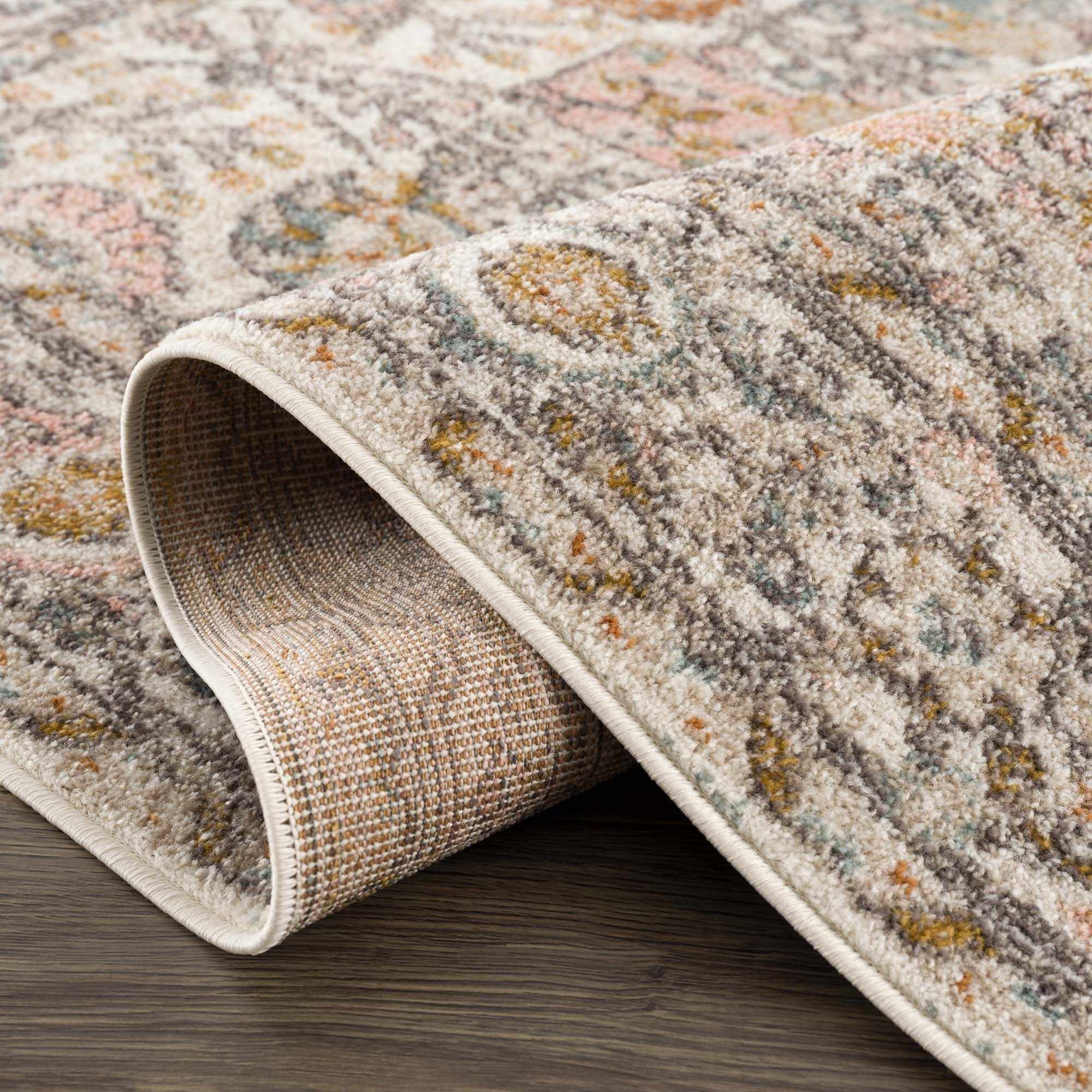 Herstmonceux traditional area rug with vintage pattern in charcoal, mustard, dusty pink, and off-white tones on a medium pile