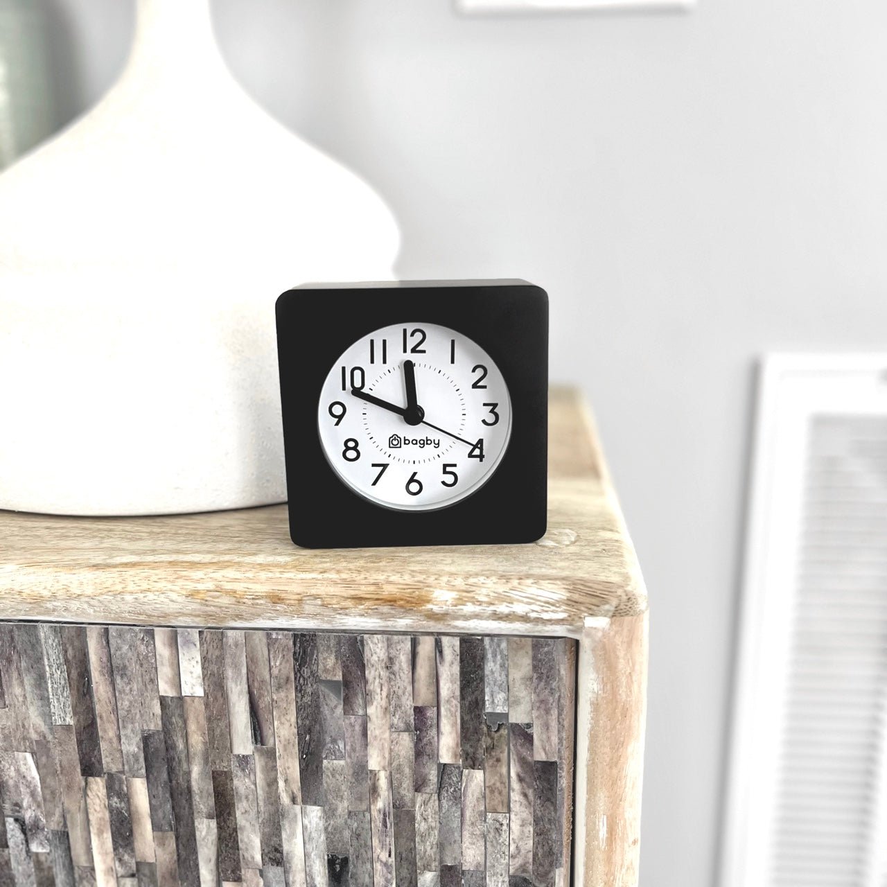 Bagby Classic solid wood analog alarm clock with numbered dial and night light on a nightstand