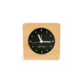 Bagby Minimalist analog alarm clock with solid wood frame and number-free dial on a nightstand