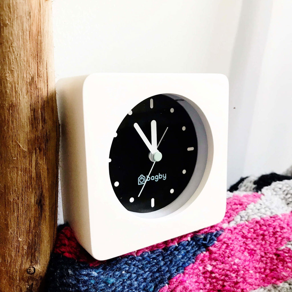 Bagby Minimalist analog alarm clock with solid wood frame and number-free dial on a nightstand