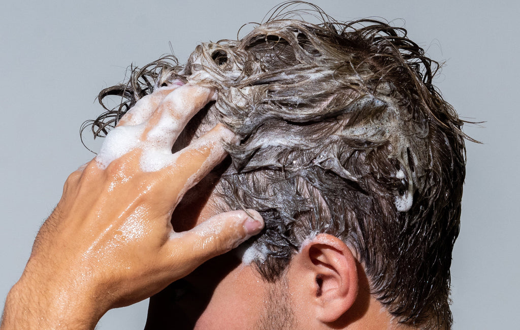 Bottle of natural daily shampoo with saw palmetto and vegan biotin on a clean surface