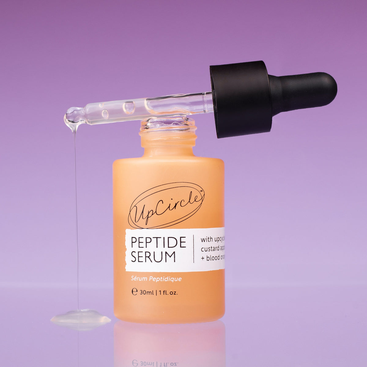 UpCircle Peptide Serum with Custard Apple and Blood Orange in a glass bottle, with a dropper and a skincare background