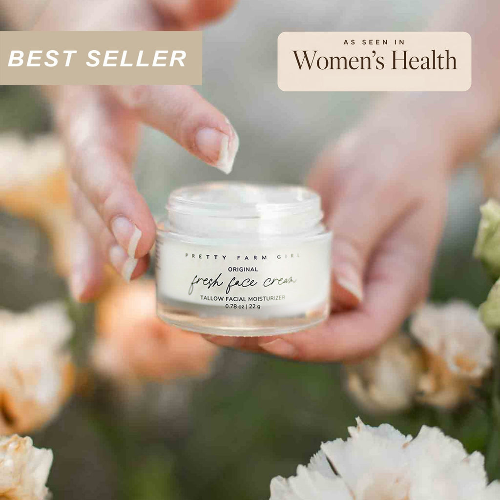 Small glass jar of tallow anti-aging face moisturizer with black lid on a clean surface