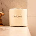 Stack of individually wrapped 100% bamboo toilet paper rolls on a bathroom shelf