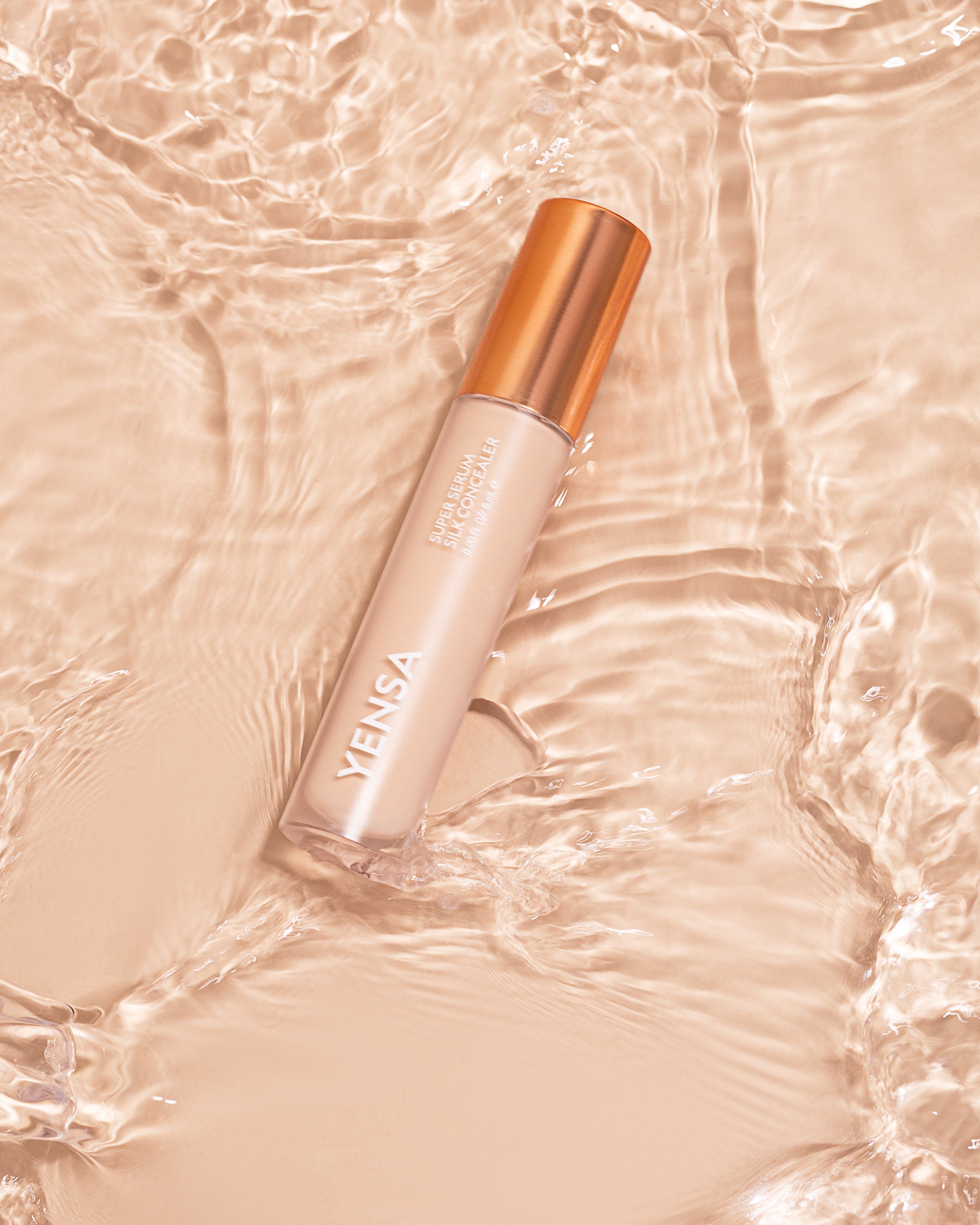 YENSA Super Serum Silk Concealer tube with soft-focus under-eye swatch on medium skin tone
