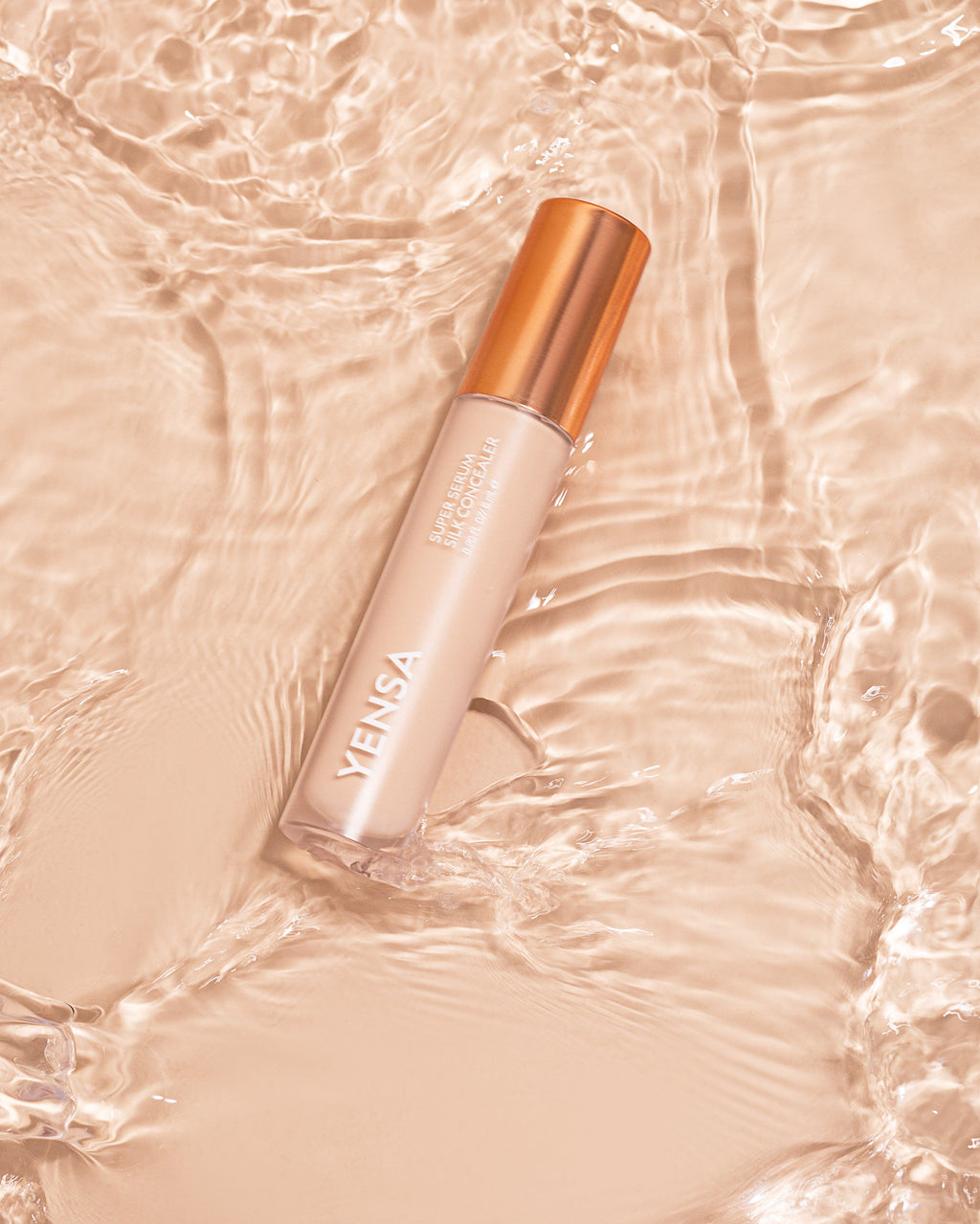 YENSA Super Serum Silk Concealer tube with soft-focus under-eye swatch on medium skin tone