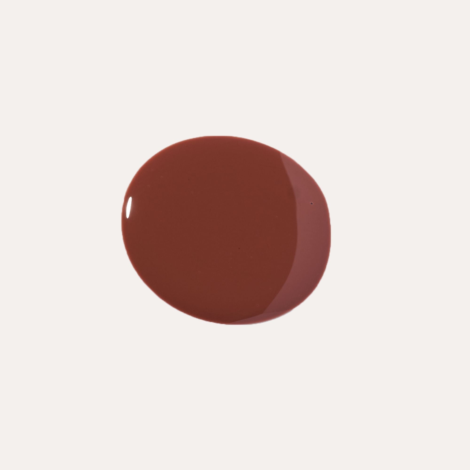 Close-up of tinted lip oil wand resting against soft-focus lips with a glossy, sheer finish
