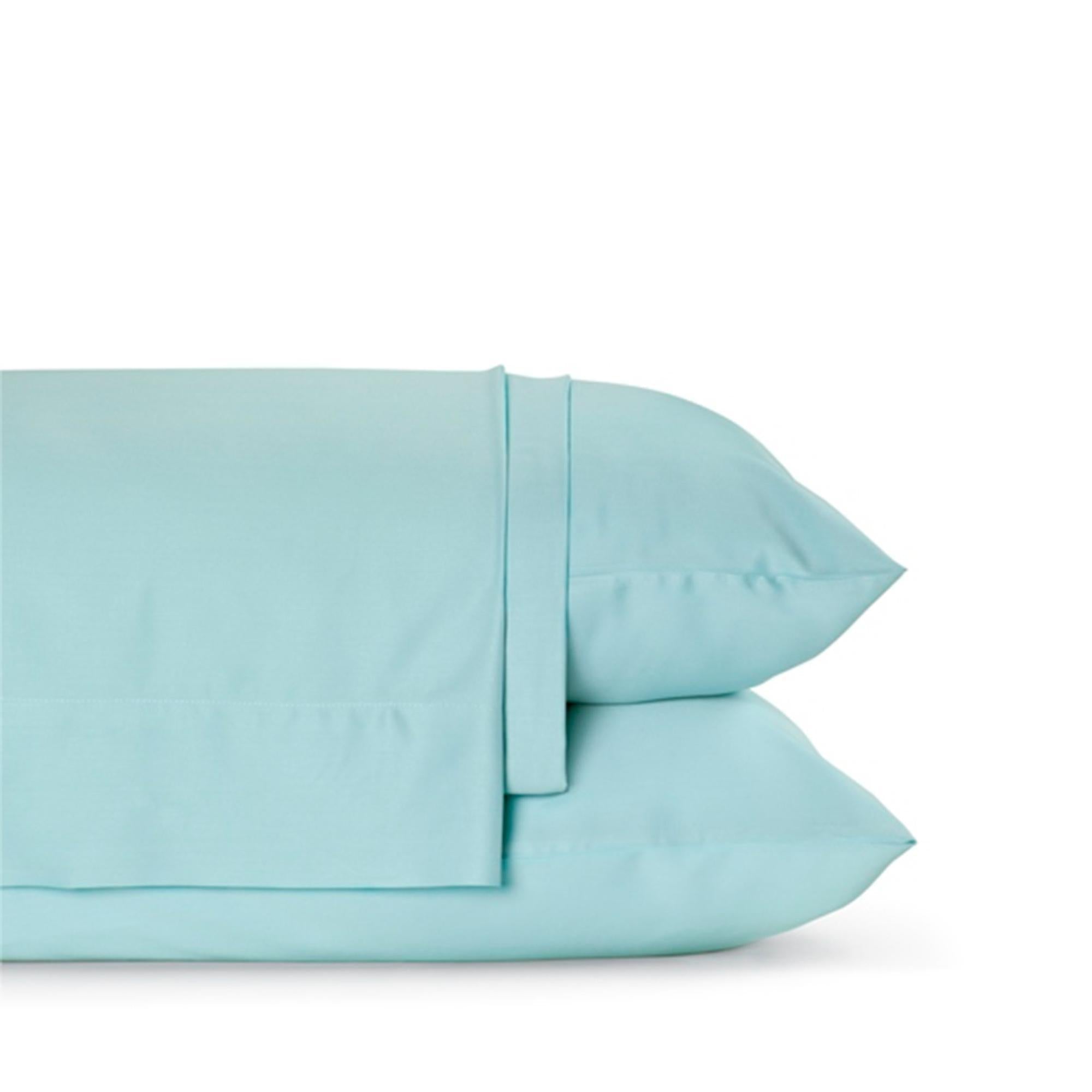 Four-piece bamboo viscose sheet set in neutral tone draped over a neatly made bed, showing silky smooth fabric texture