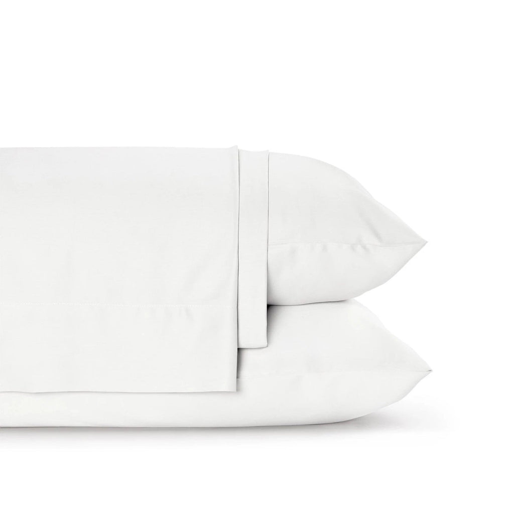 Four-piece bamboo viscose sheet set in neutral tone draped over a neatly made bed, showing silky smooth fabric texture
