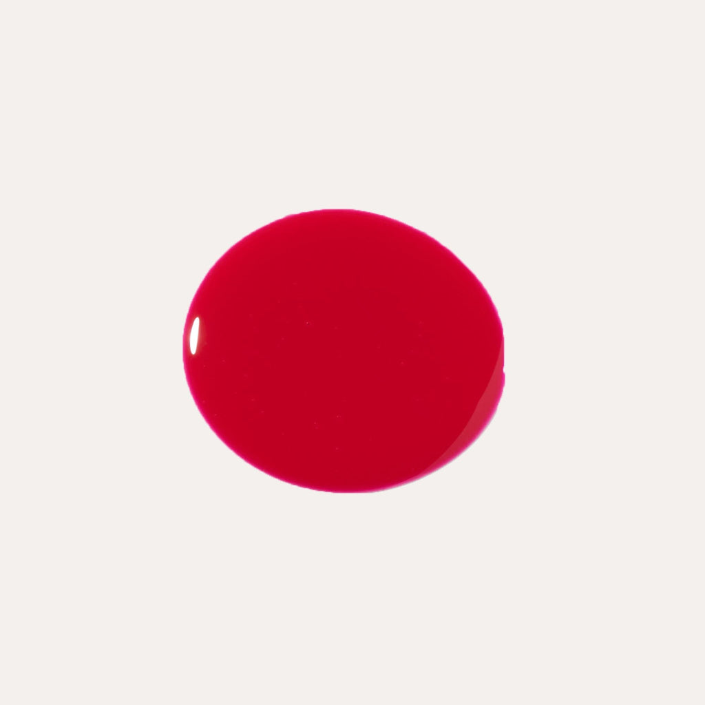 Close-up of tinted lip oil wand resting against soft-focus lips with a glossy, sheer finish