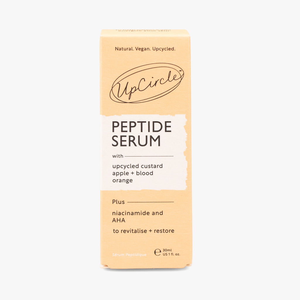 UpCircle Peptide Serum with Custard Apple and Blood Orange in a glass bottle, with a dropper and a skincare background
