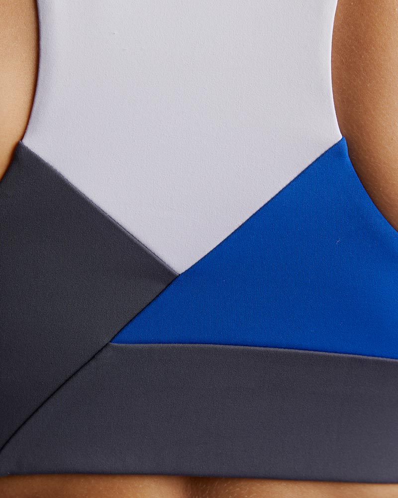 Pionxr color-block sports bra top with flat seam construction and longer cropped length in bold two-tone colorway