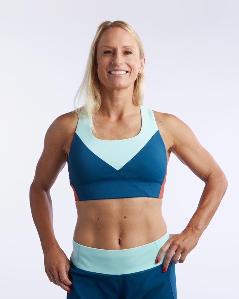 Pionxr color-block sports bra top with flat seam construction and longer cropped length in bold two-tone colorway