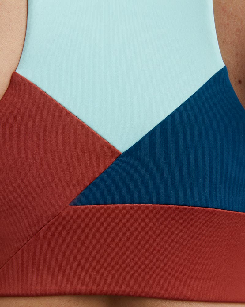 Pionxr color-block sports bra top with flat seam construction and longer cropped length in bold two-tone colorway