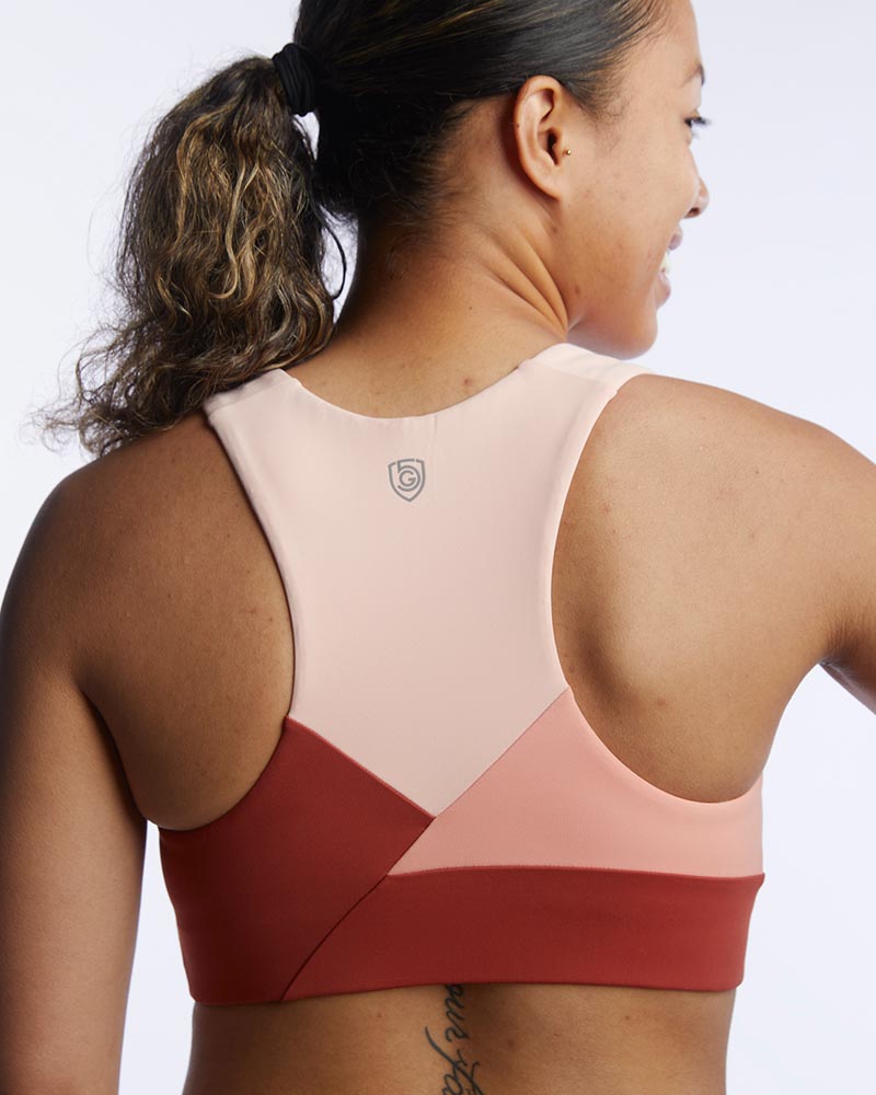 Pionxr color-block sports bra top with flat seam construction and longer cropped length in bold two-tone colorway