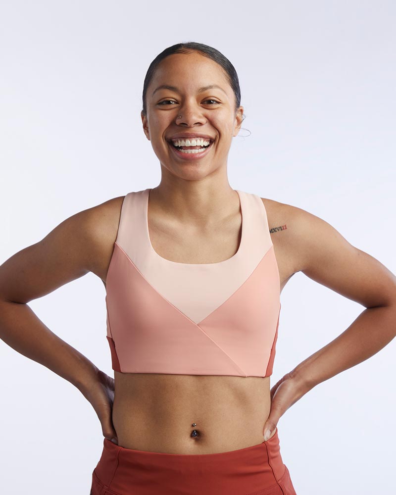 Pionxr color-block sports bra top with flat seam construction and longer cropped length in bold two-tone colorway