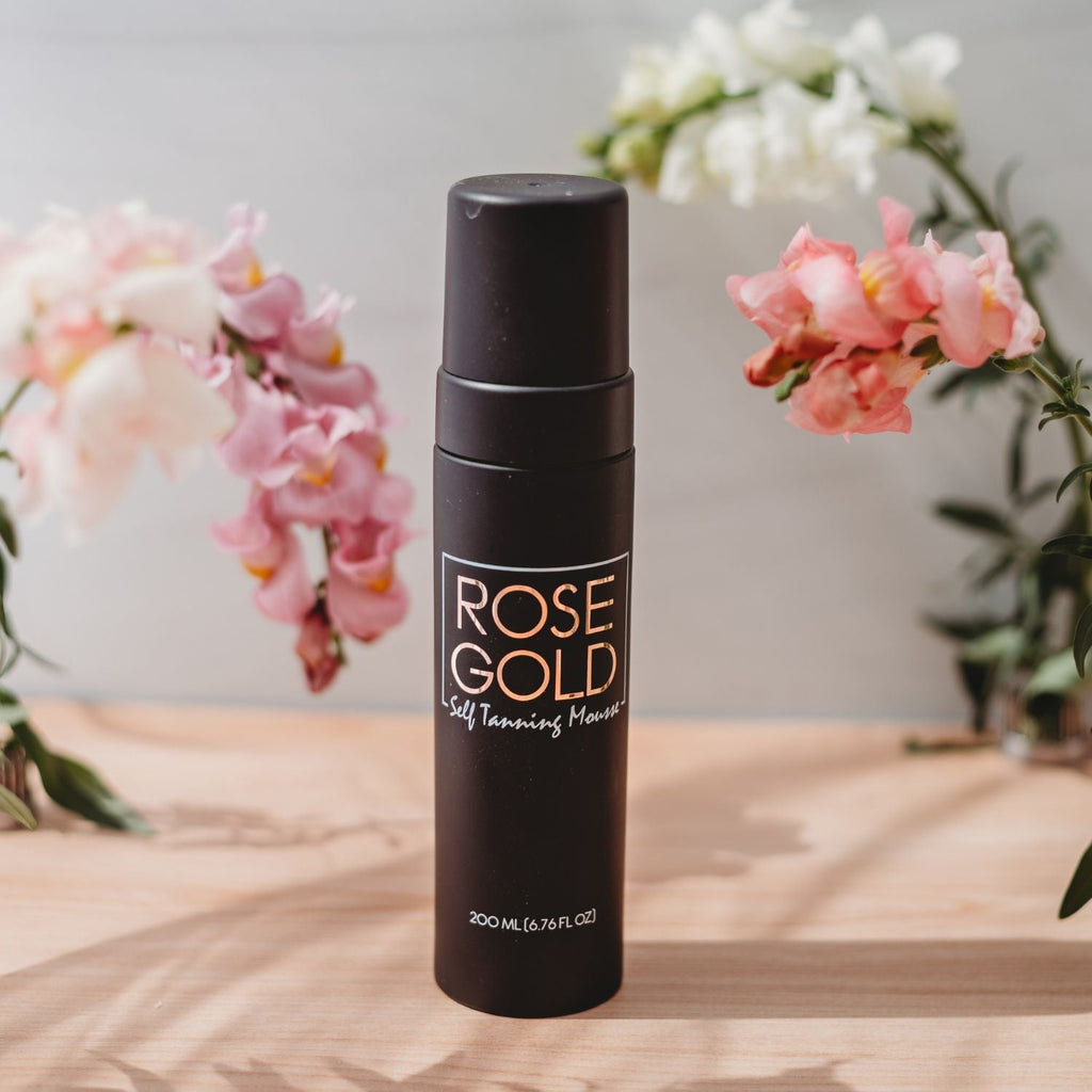 Dark neutral bronze self-tanning mousse in whipped foam texture, shown with applicator on light background