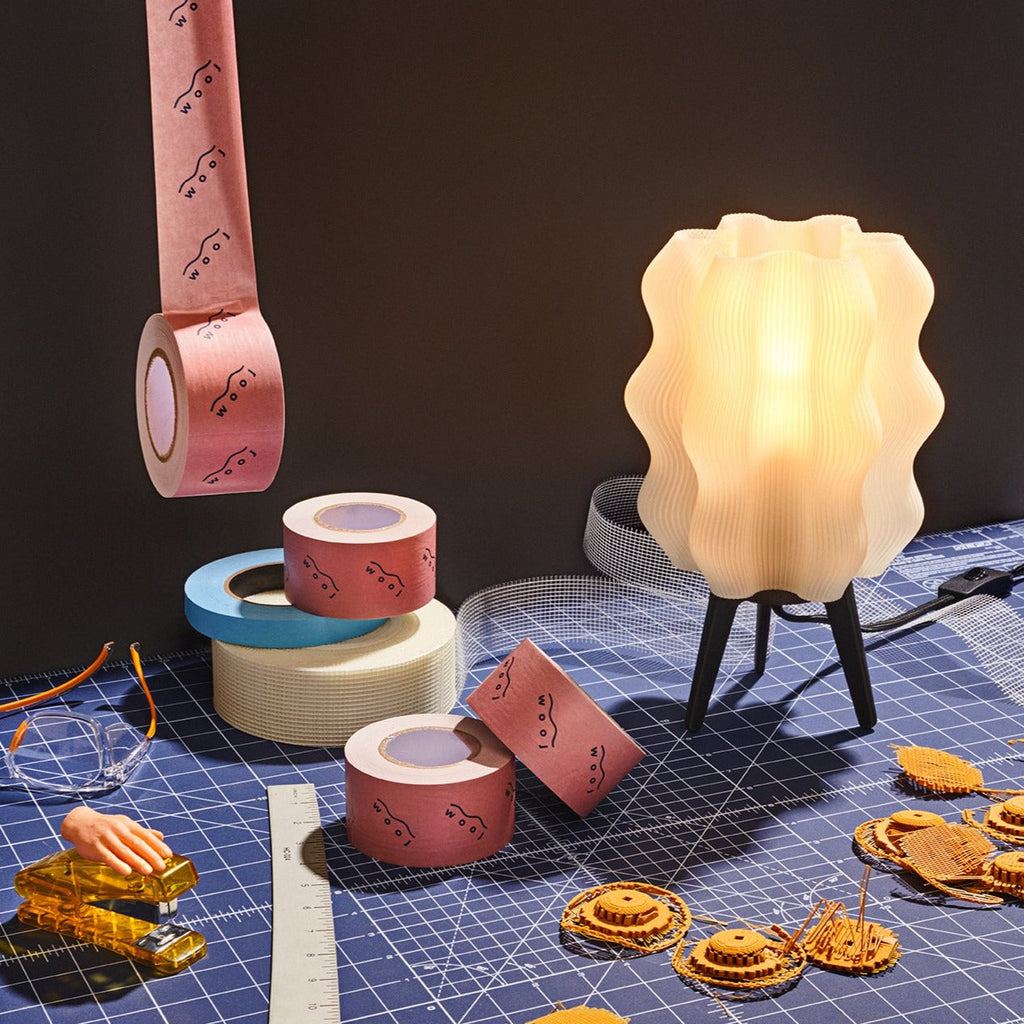 Wavy sculptural table lamp in recycled corn-based plastic with organic rippled silhouette on a flat surface
