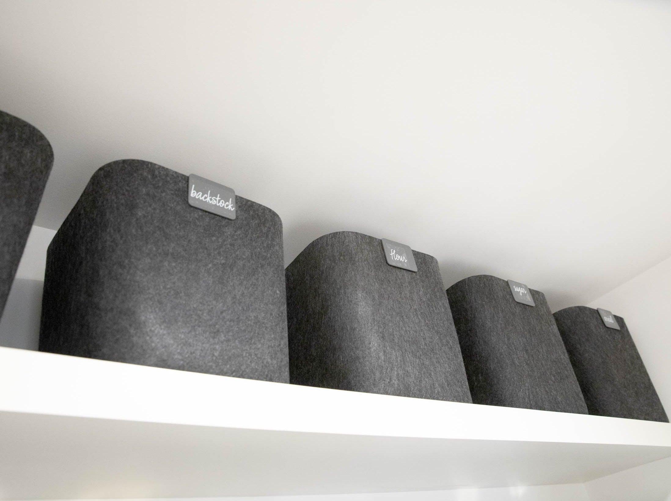 SortJoy Sculpted Storage Bin in Carbon colorway, structured shape on a shelf holding folded linens