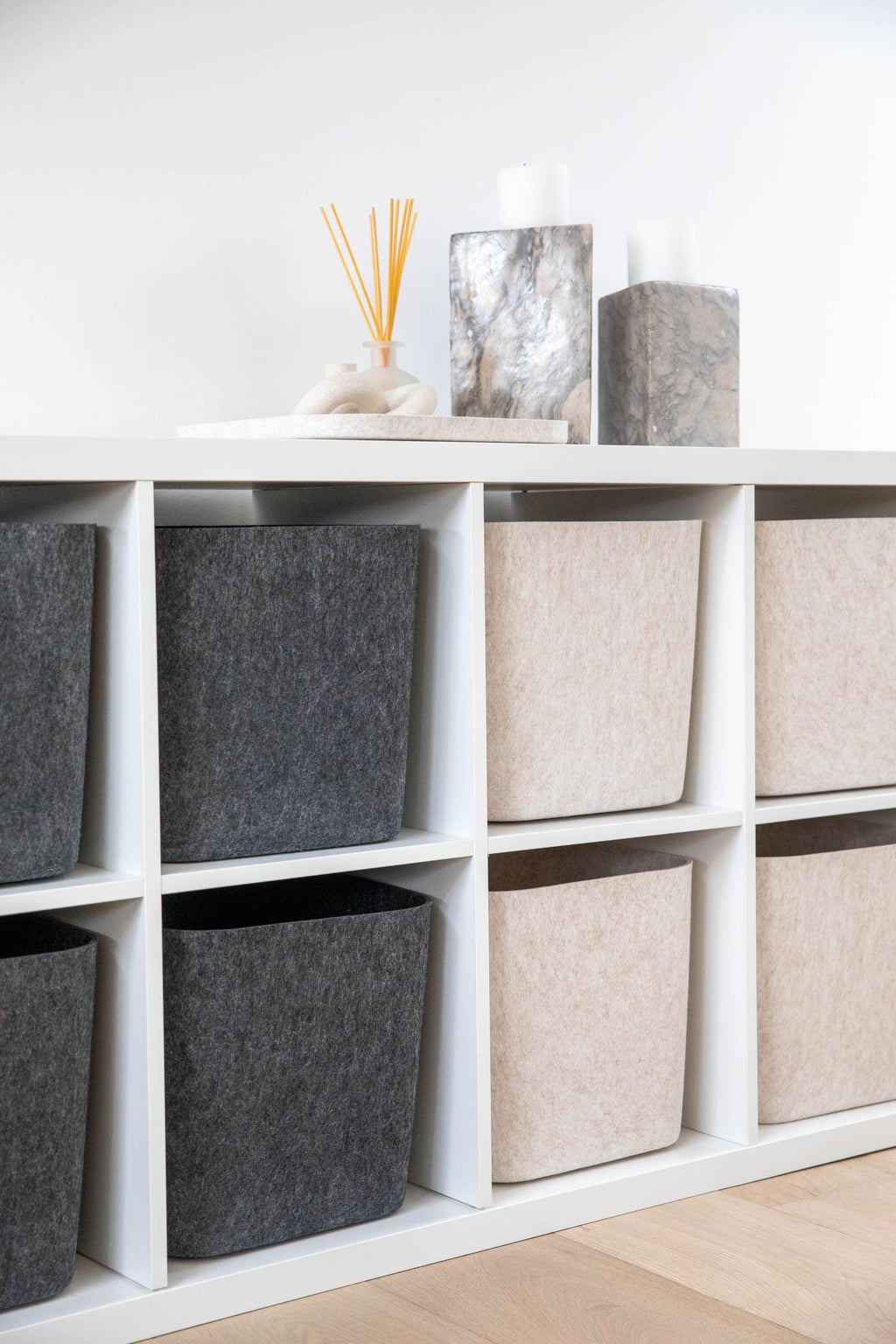 SortJoy Sculpted Storage Bin in Carbon colorway, structured shape on a shelf holding folded linens