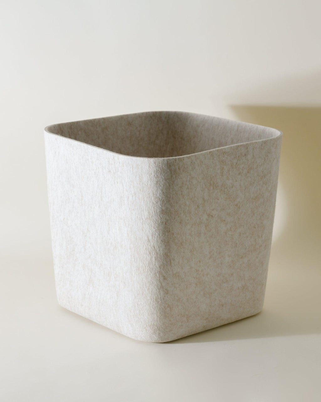 SortJoy Sculpted Storage Bin in Carbon colorway, structured shape on a shelf holding folded linens