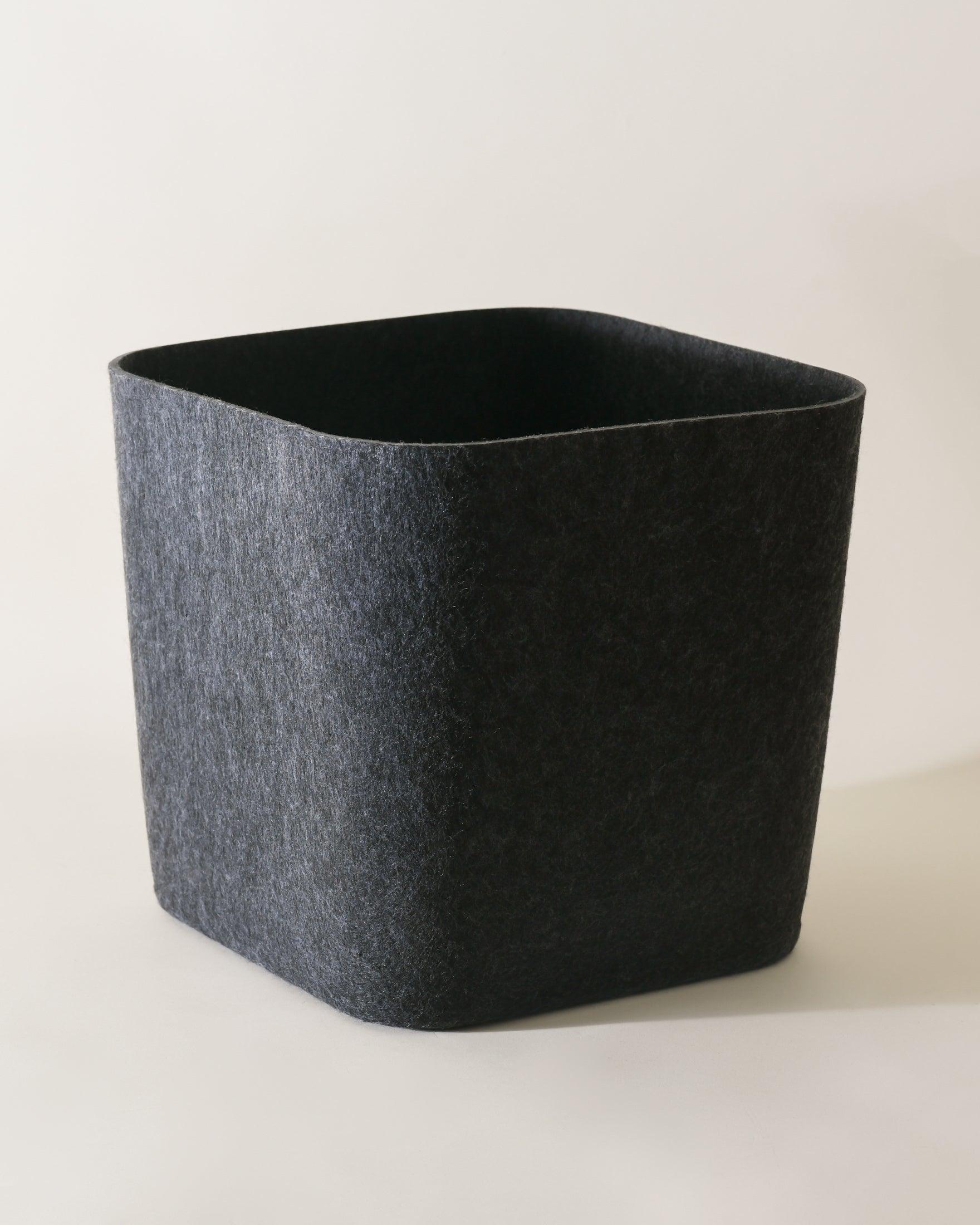 SortJoy Sculpted Storage Bin in Carbon colorway, structured shape on a shelf holding folded linens